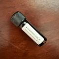 01 Boston Lore hand-blended fountain pen ink in a 5 mL glass Archive Bottle on a wooden desk