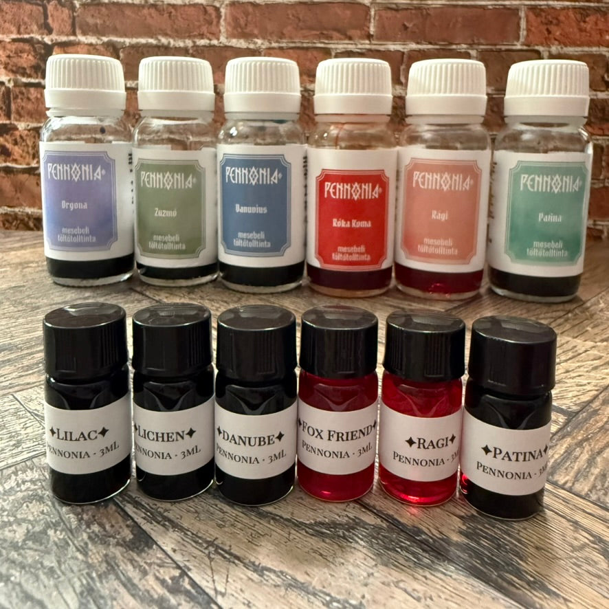 Six 3 mL Pennonia sample vials (Lilac, Lichen, Danube, Fox Friend, Ragi, Patina) in front of the matching Pennonia bottles they were decanted from (bottles not included)