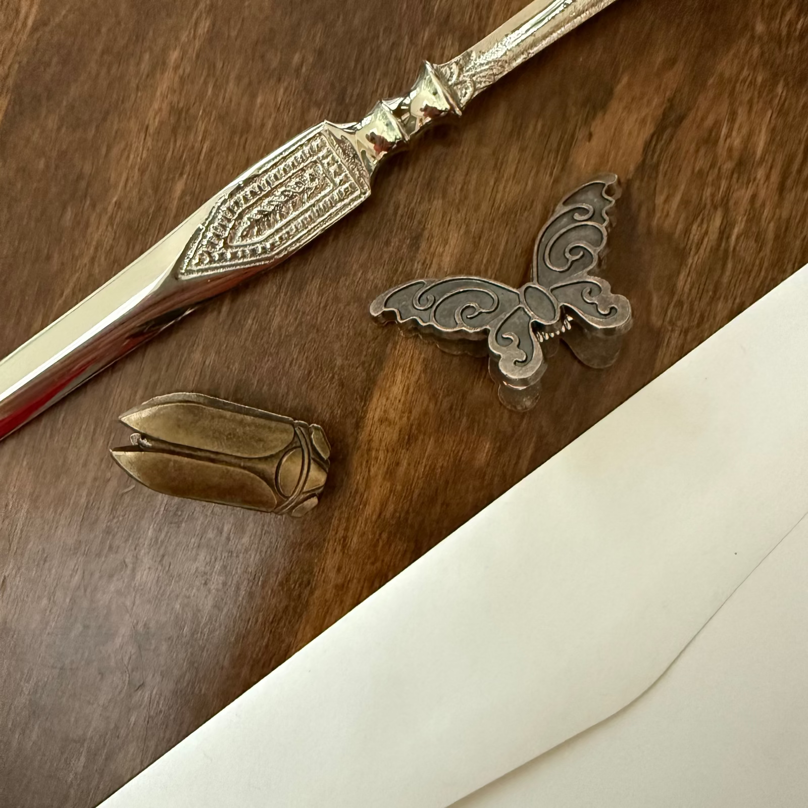 Antique brass butterfly and beetle journal clips styled with writing desk objects