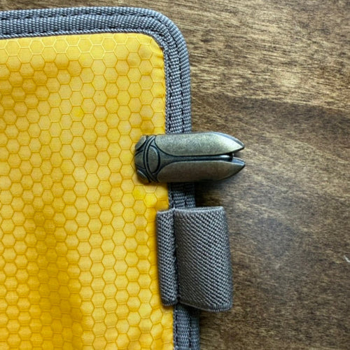Small beetle journal clip attached to the edge of a notebook