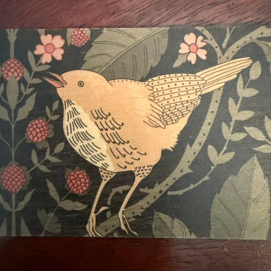 Close-up of bird and botanical artwork printed on natural wood bookmark