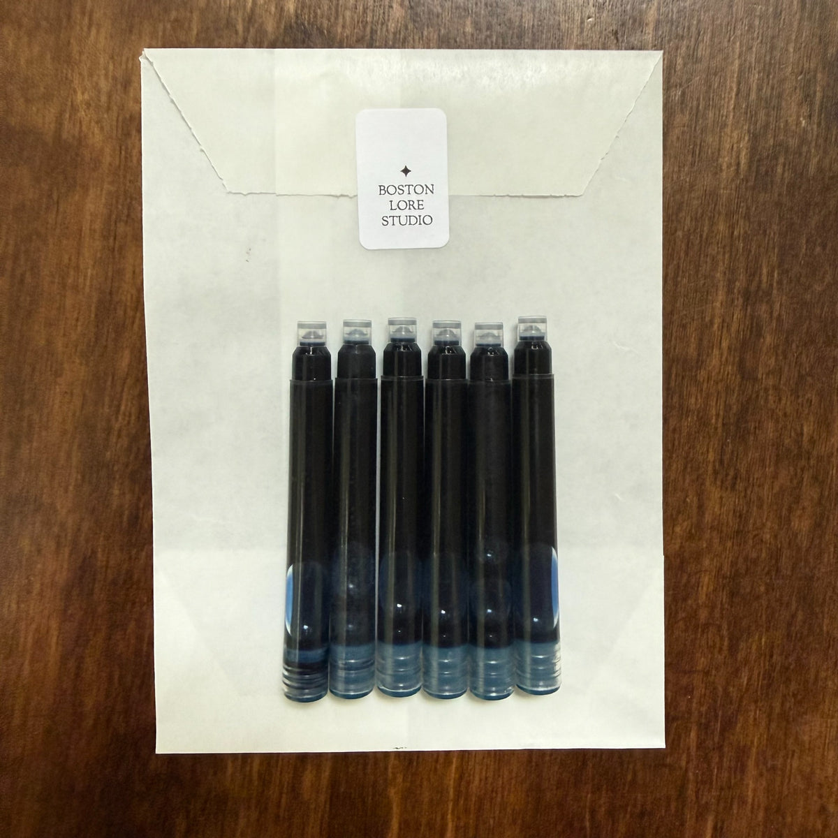 Six blue short international fountain pen ink cartridges with Boston Lore Studio glassine envelope