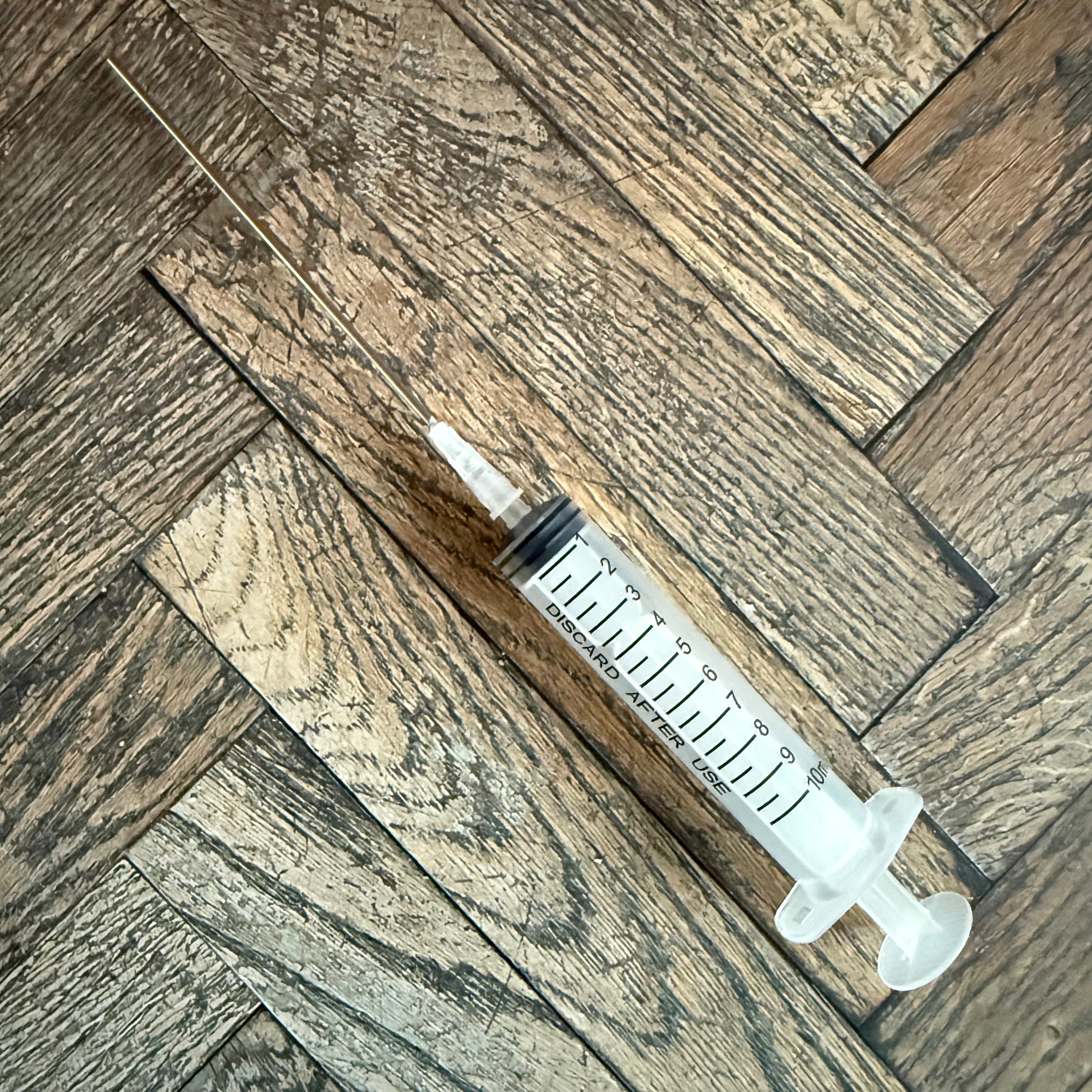 Full view of the 10 mL ink syringe with extra-long blunt needle and clear graduated barrel