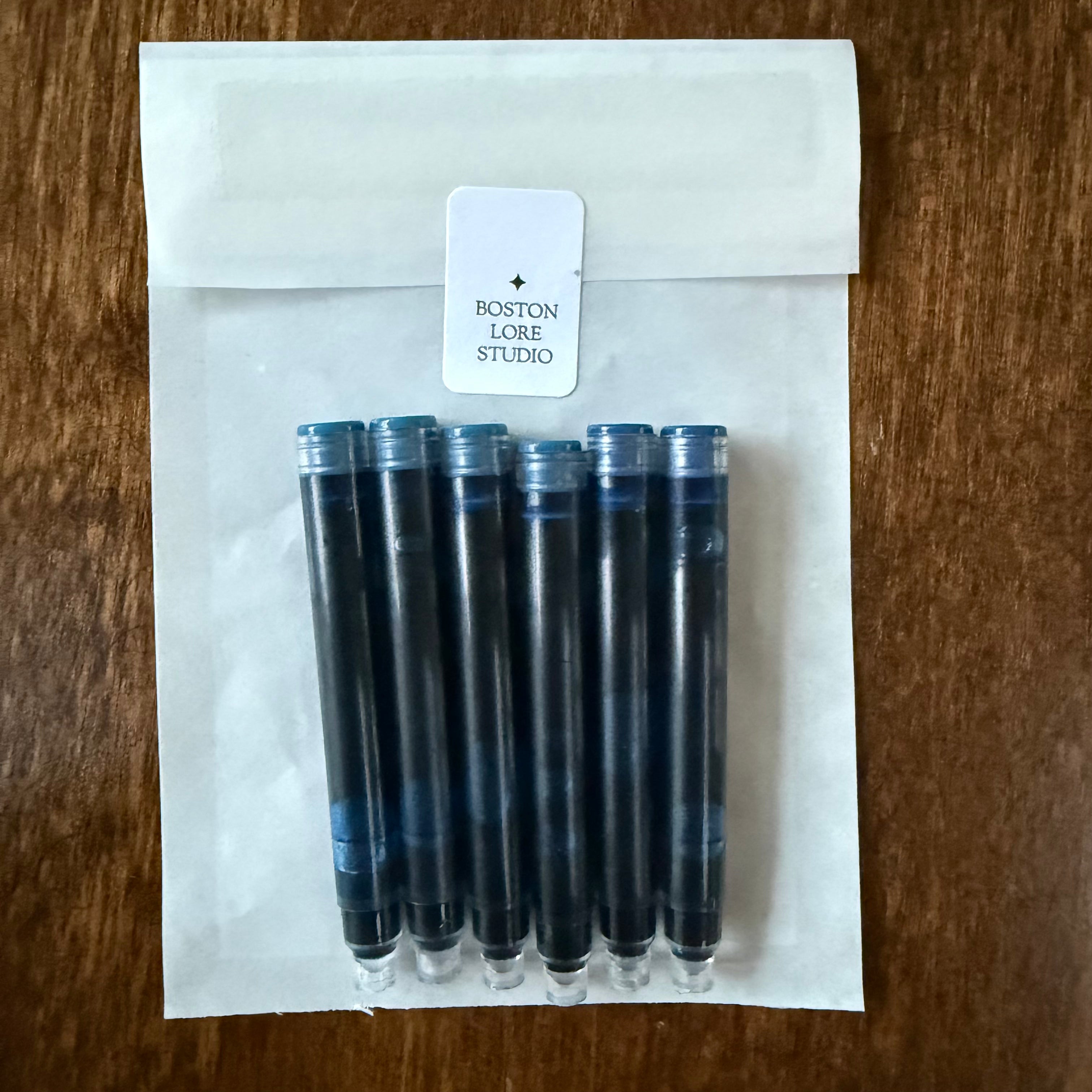 Six blue-black international fountain pen ink cartridges in a Boston Lore Studio glassine envelope