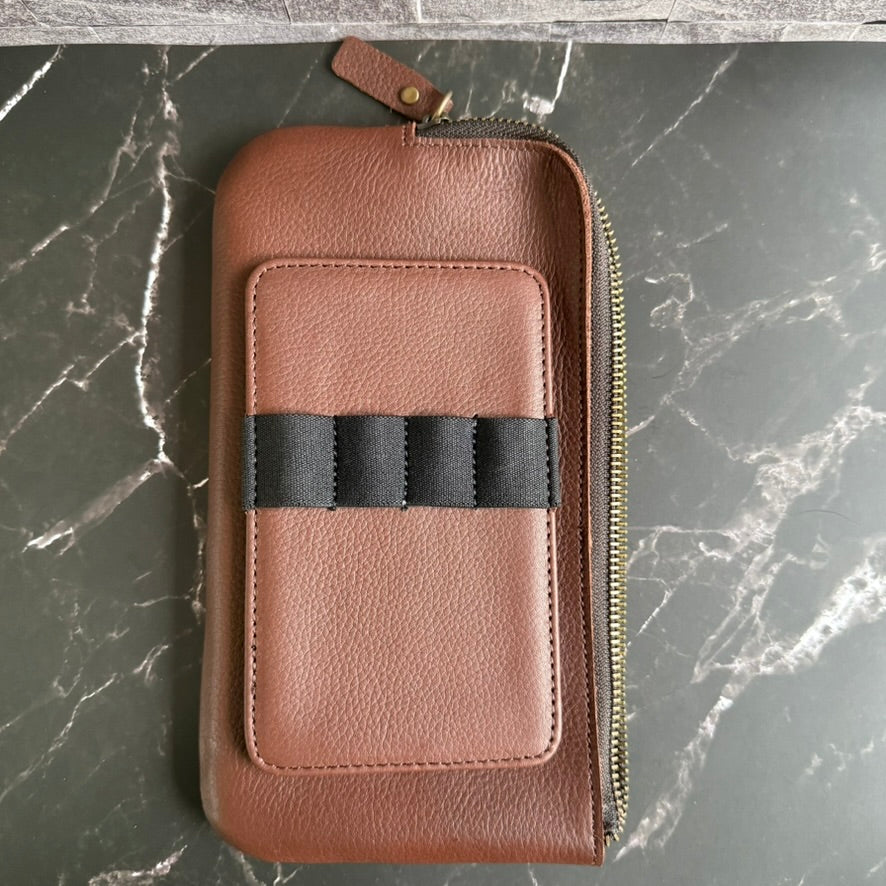 Espresso brown cowhide leather zipper case lying flat with its matching four-pen insert on top, brass zipper along the side