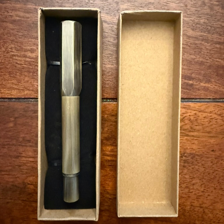 Compact brushed brass pocket fountain pen presented in a kraft paper box with black insert