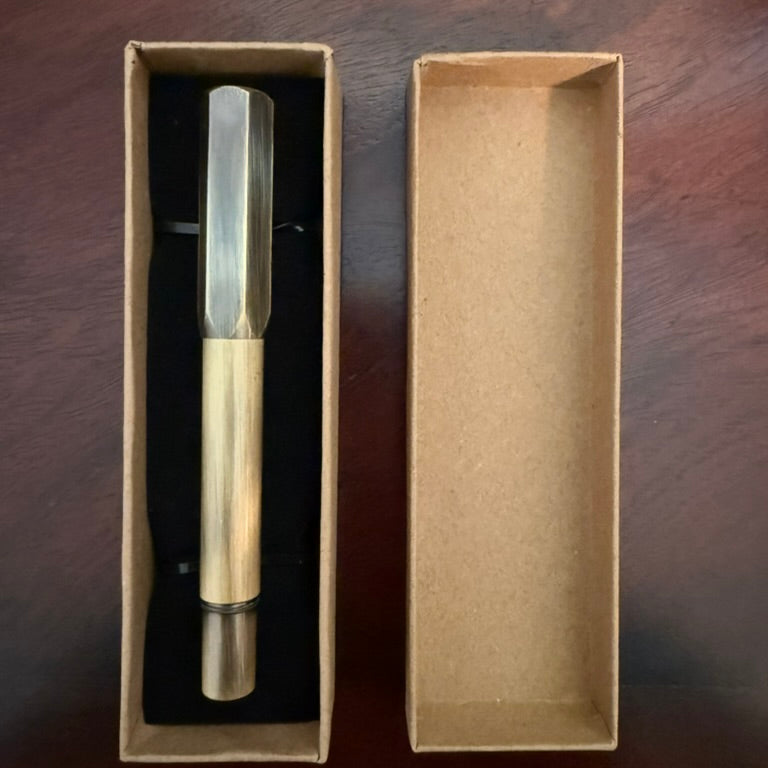 Compact brushed brass pocket fountain pen presented in a kraft paper box with black insert
