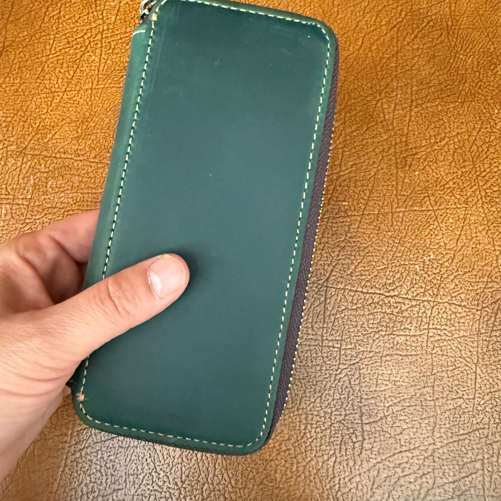 Green leather 3-pen fountain pen case held in hand for scale