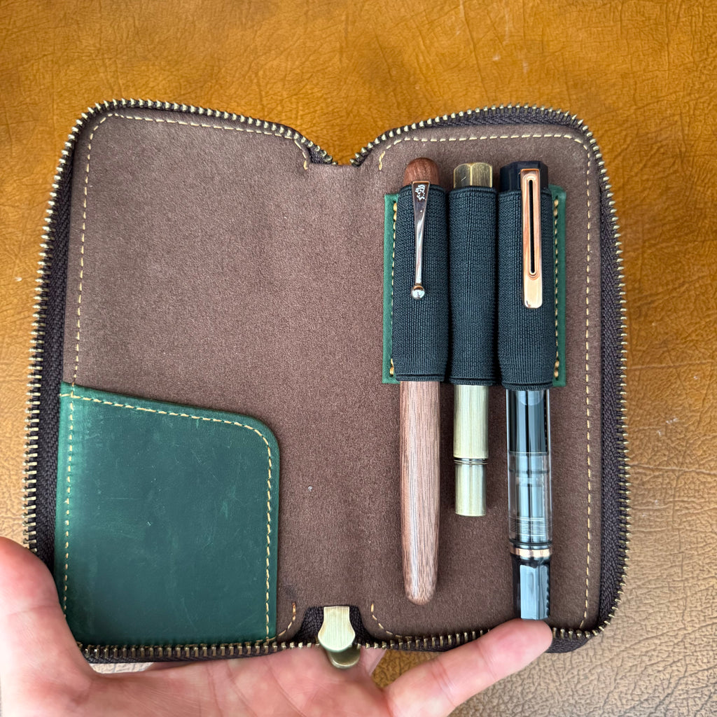 Open green leather 3-pen fountain pen case holding fountain pens