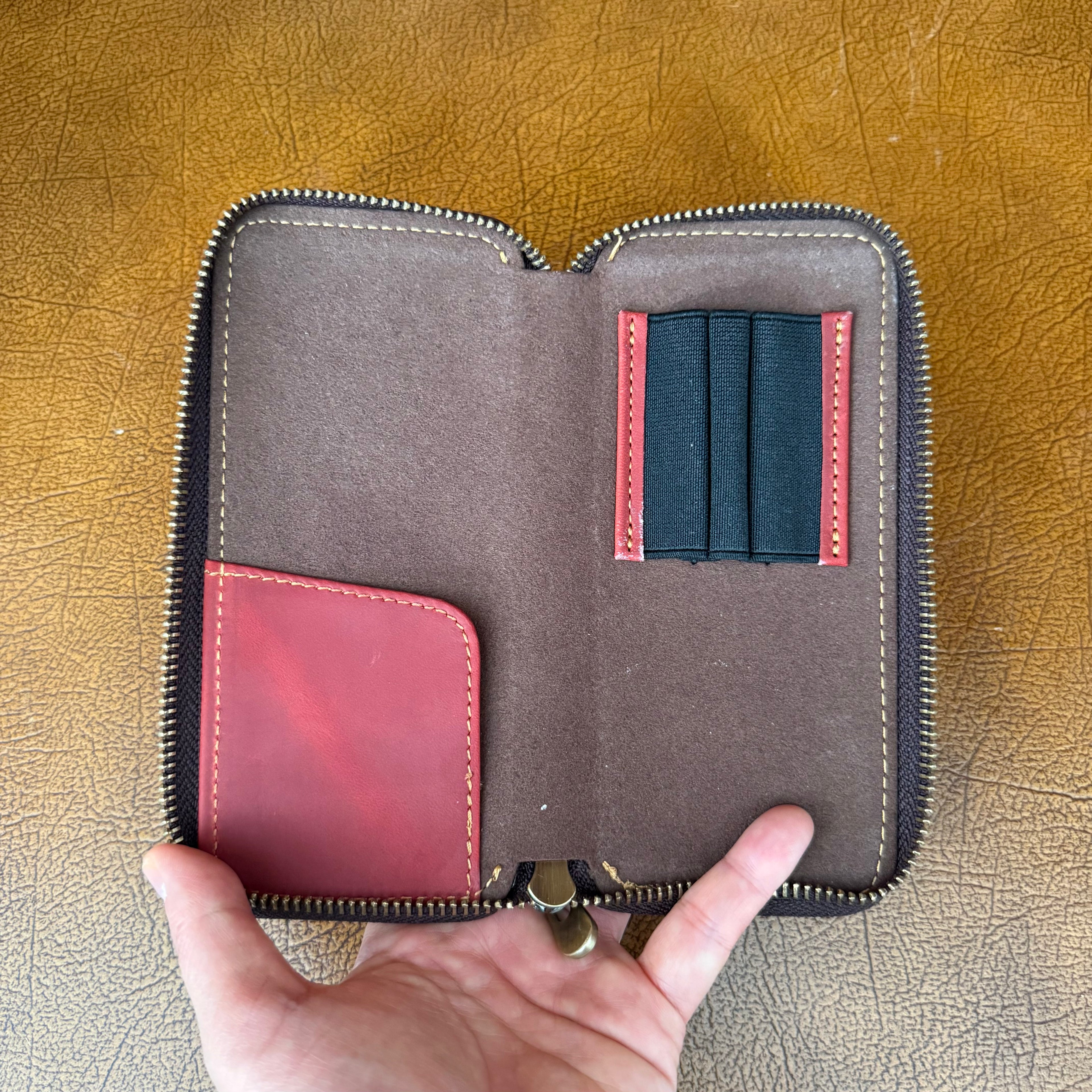 Open wine red leather 3-pen pen case showing interior pen slots and stitching