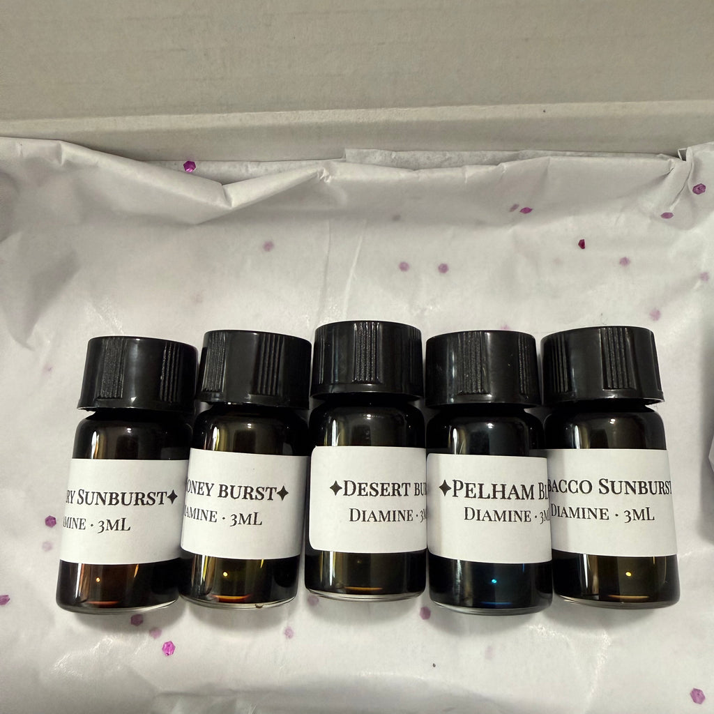 Five labeled Diamine Guitar 3 mL ink vials resting on white tissue paper with purple confetti