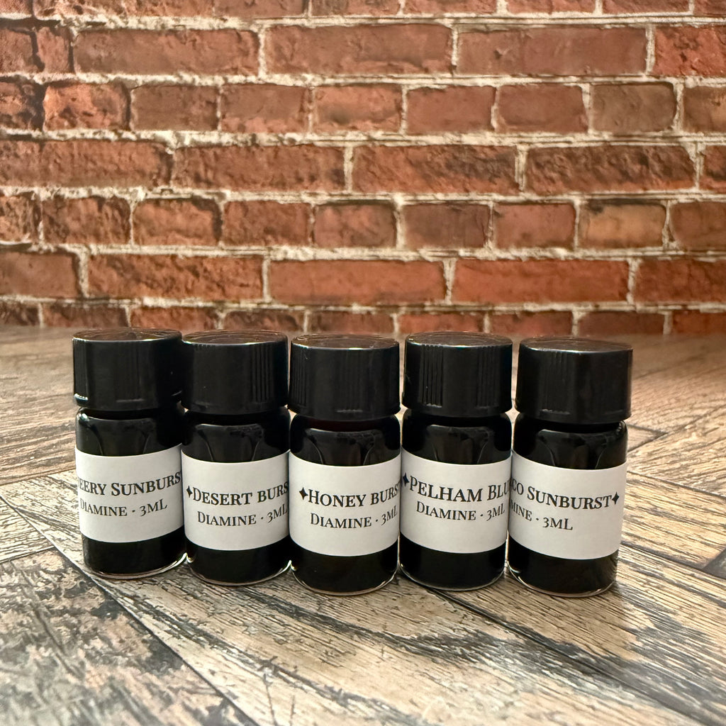 Five 3 mL glass vials of Diamine Guitar series ink labeled Cherry Sunburst, Desert Burst, Honey Burst, Pelham Blue and Tobacco Sunburst