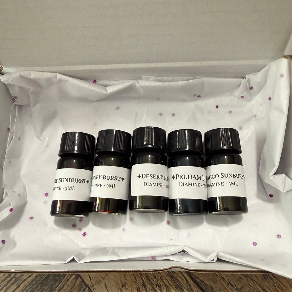 Open gift box with tissue holding five Diamine Guitar series 3 mL ink sample vials