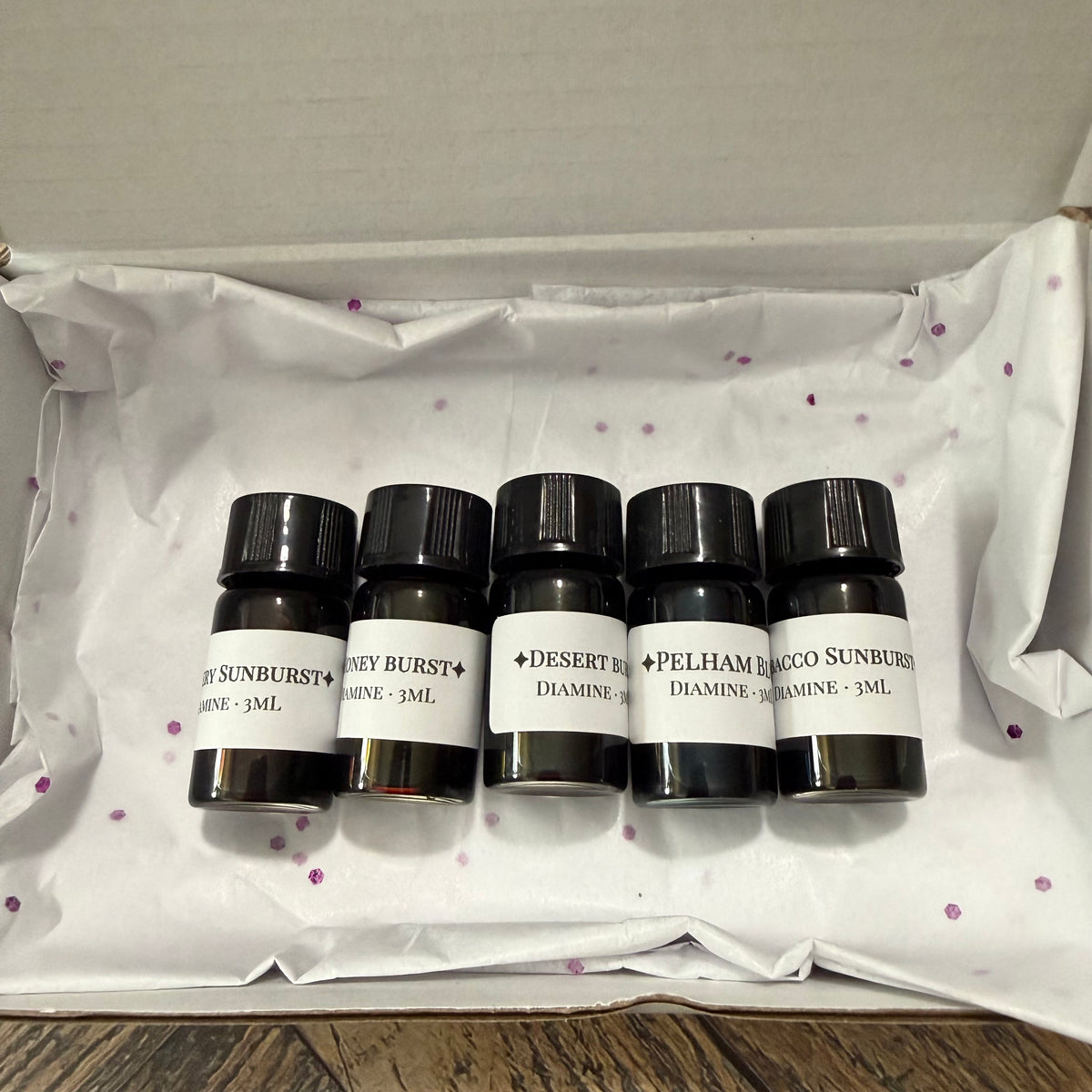 Open gift box with tissue holding five Diamine Guitar series 3 mL ink sample vials