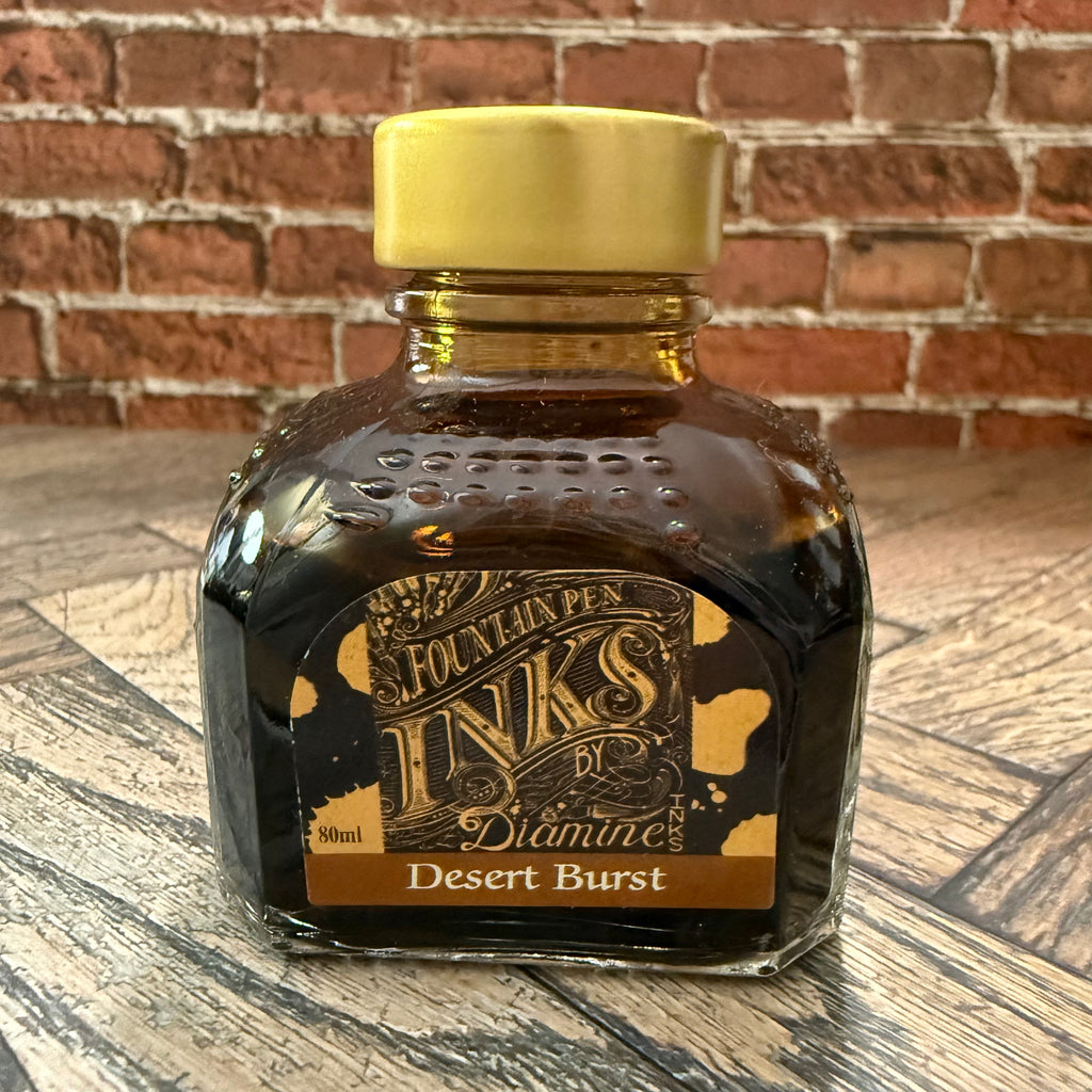 Diamine Desert Burst golden brown fountain pen ink in an 80 mL glass bottle with a gold cap