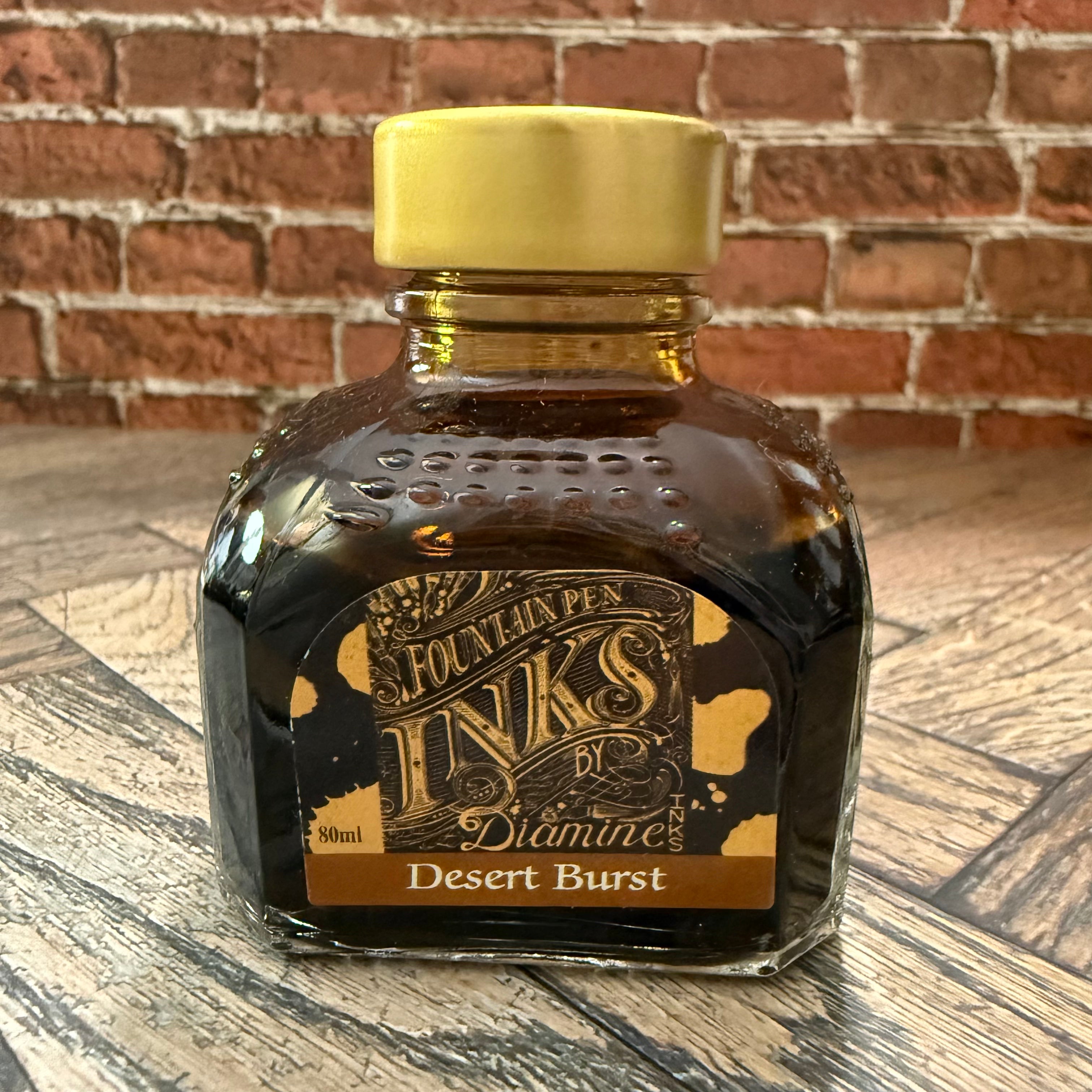 Diamine Desert Burst golden brown fountain pen ink in an 80 mL glass bottle with a gold cap