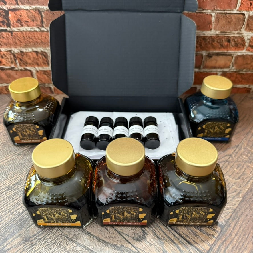Diamine Guitar series 5 x 5 mL ink sampler in an open gift box, surrounded by the five full 80 mL Diamine bottles