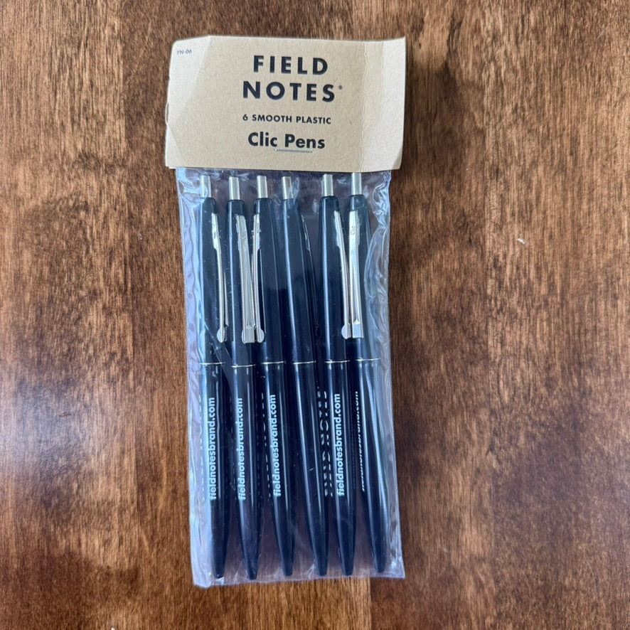 Six black Field Notes Clic ballpoint pens in retail packaging, with white barrel lettering, silver-tone clips, and push buttons