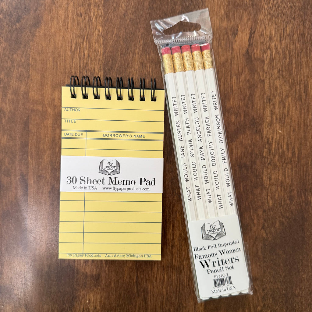 Famous Women Writers Pencil Set by Fly Paper Products beside a vintage library card memo pad on a wooden writing desk.