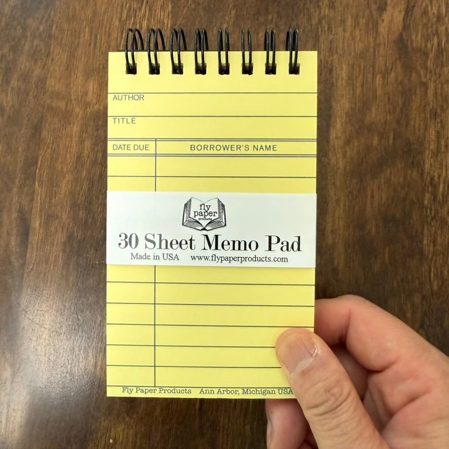 Hand holding the compact Vintage Library Card Memo Pad by Fly Paper Products, showing its 5 × 3 inch size.