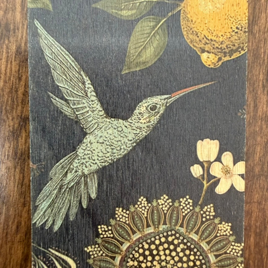 Close-up of hummingbird and lemon artwork on natural wood bookmark
