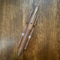 Jinhao 9035 Walnut fountain pen capped on a wooden desk