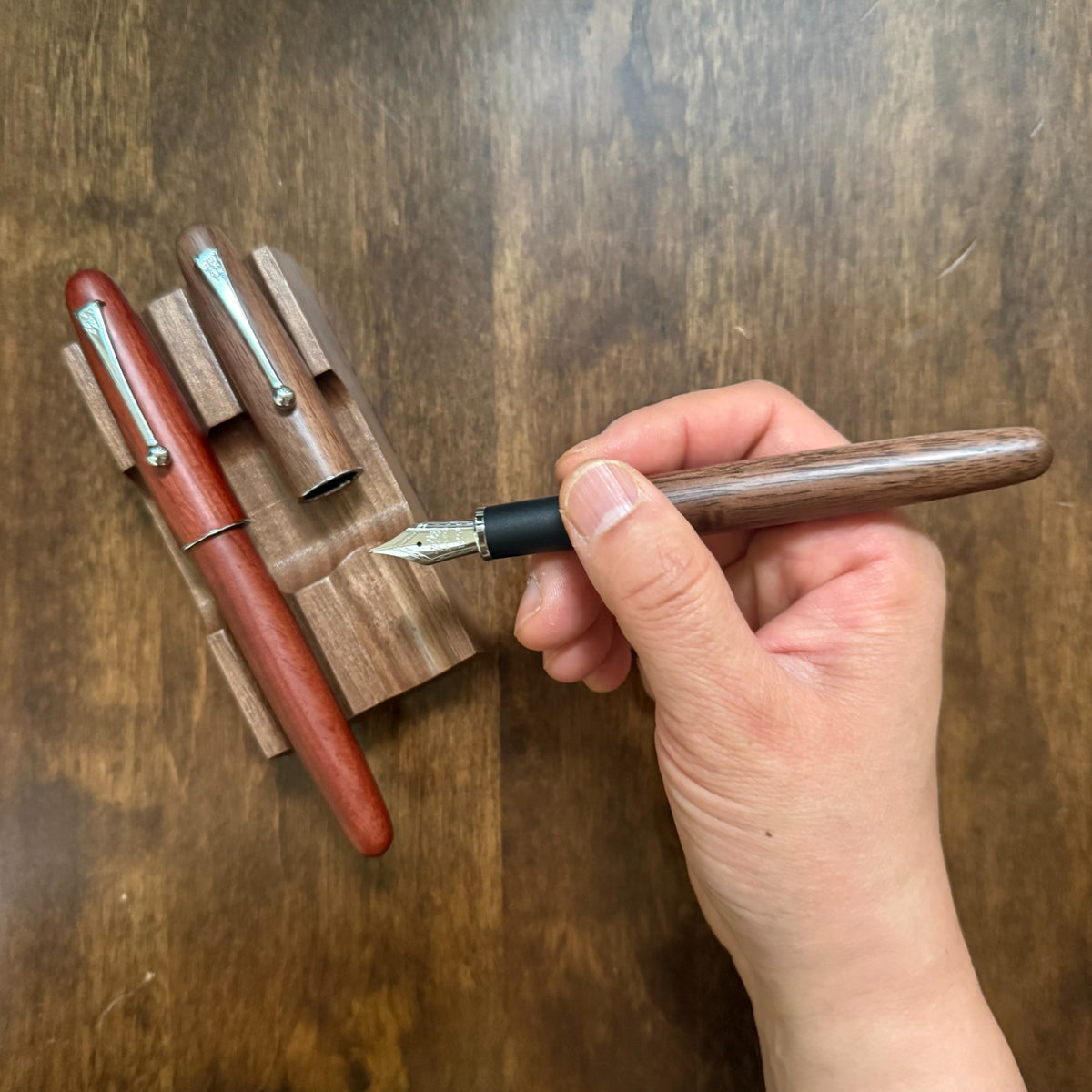 Jinhao 9035 Walnut fountain pen uncapped and held in the writing position