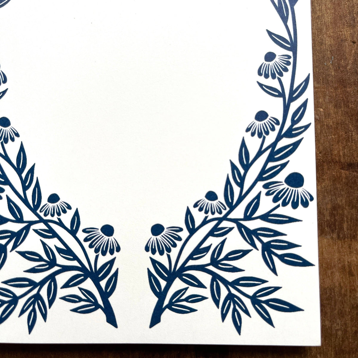 Close-up of navy echinacea botanical border on Katharine Watson market pad