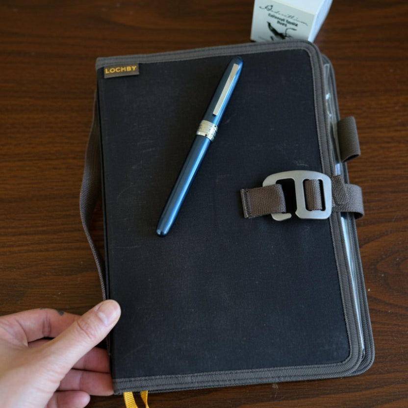 Lochby Field Journal held in hand showing the portable size of the Traveling Archivist Kit