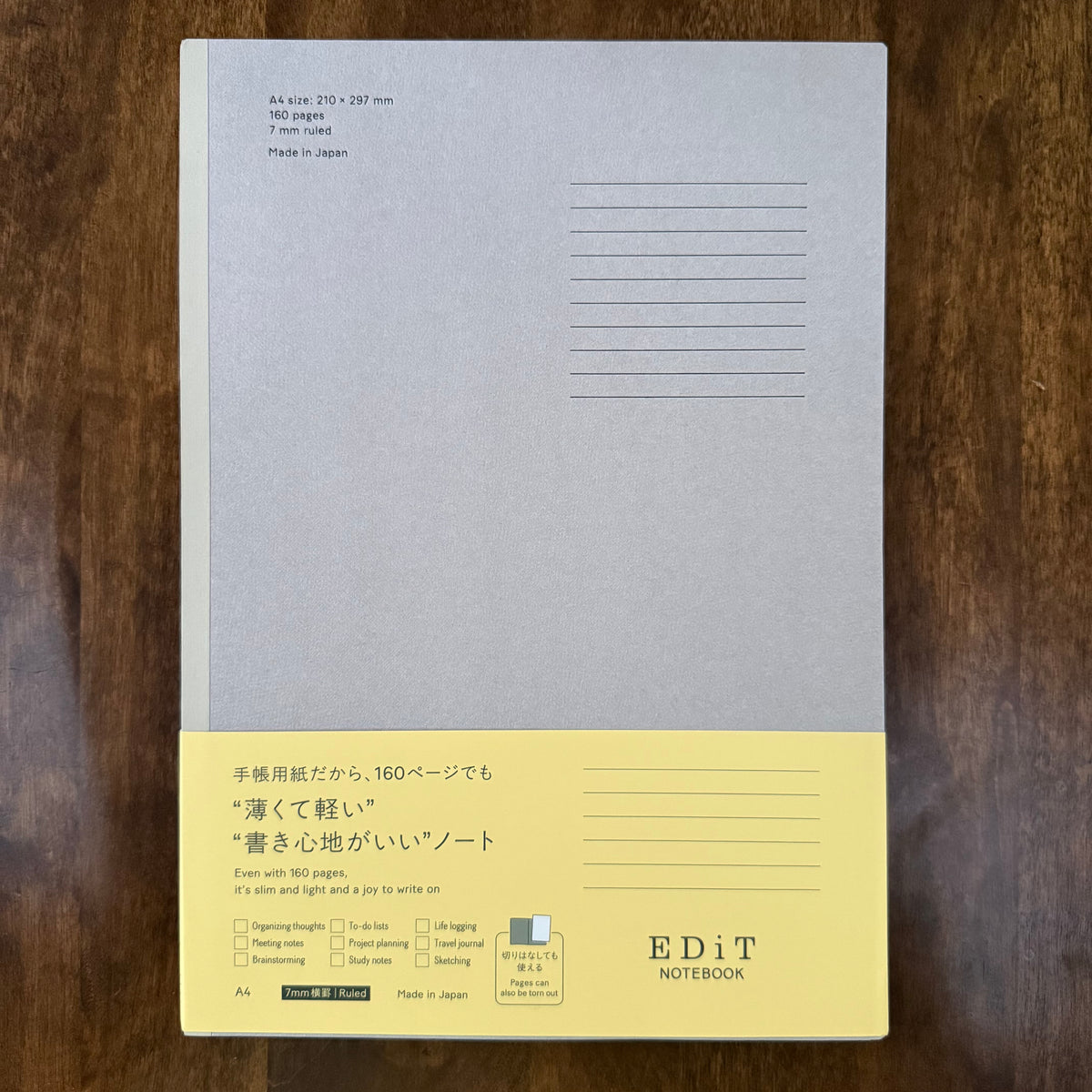 MARK’S EDiT A4 7 mm ruled notebook with a pale gray cover and yellow packaging band on a wooden surface.