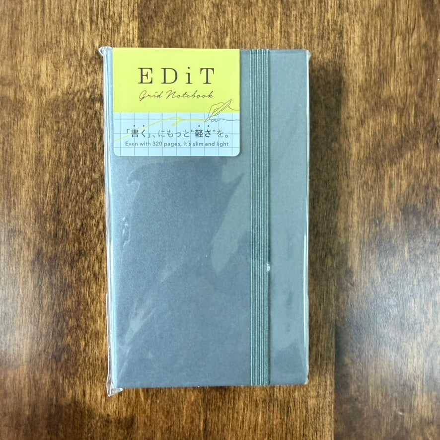 MARK'S EDiT B7 Grid Notebook in Steel Gray, packaged with a yellow label and matching elastic closure