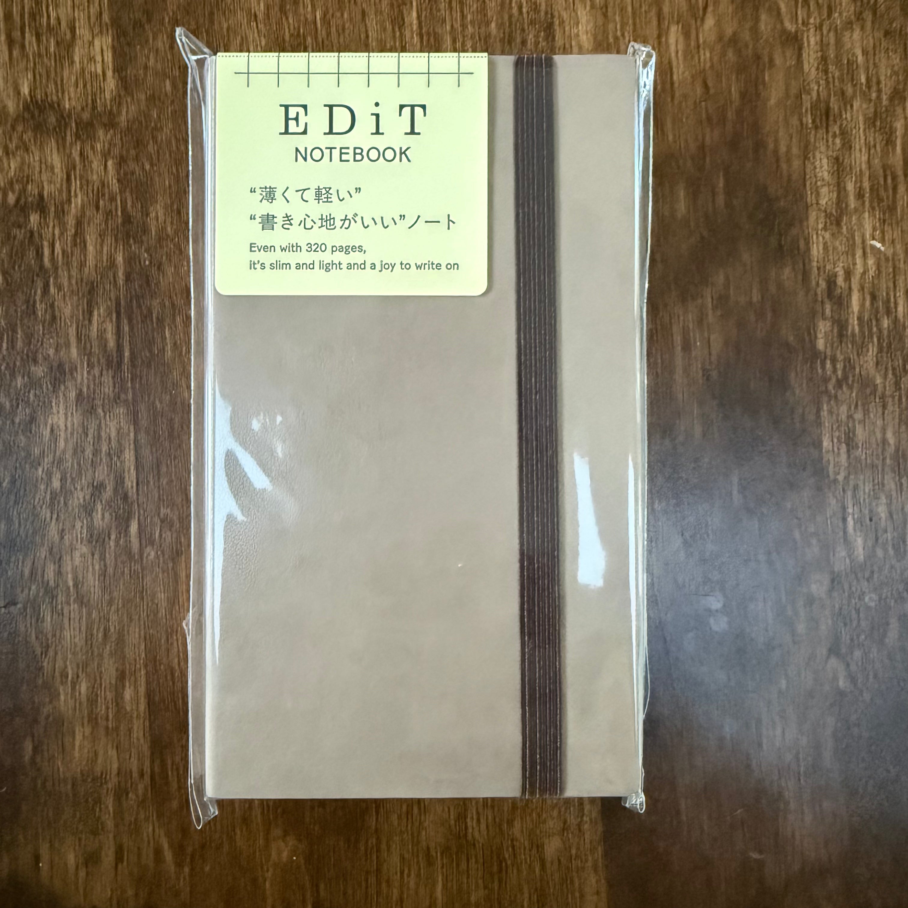 MARK’S EDiT B7 Light Latte notebook in clear packaging, with a brown elastic closure and a label identifying its 320 pages.