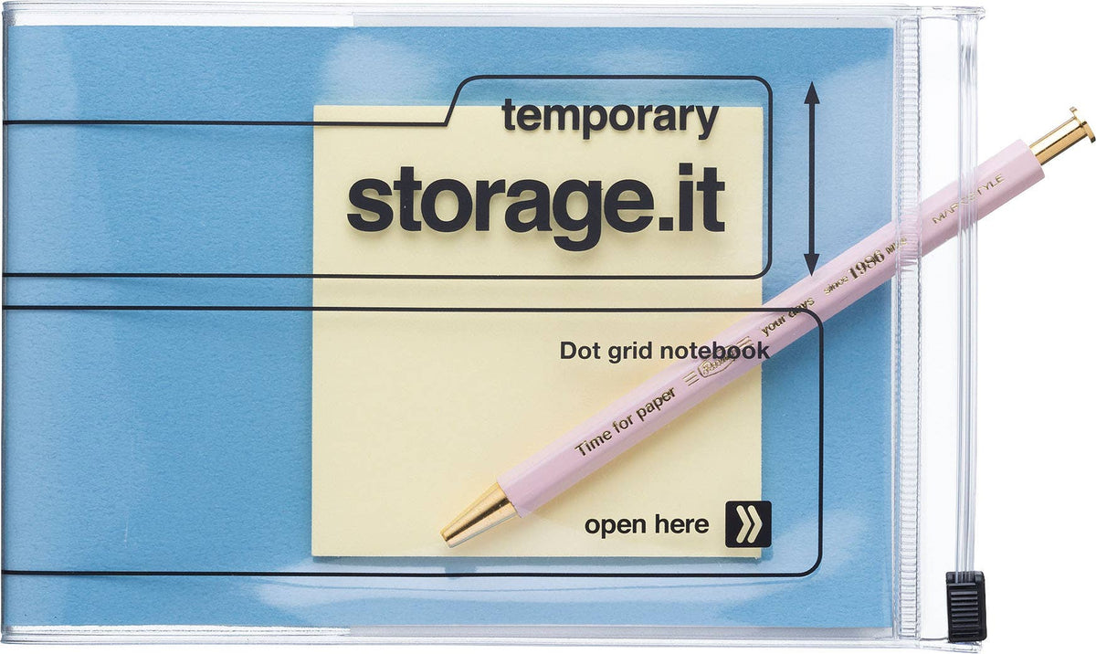Blue MARK'S Storage.it Desk notebook with a pink pen and yellow note in its clear zip storage cover, illustrating the compatible notebook system