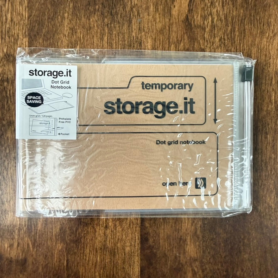 Craft MARK'S Storage.it Desk Dot Grid Notebook in retail packaging, with a tan cover, black lettering, and clear slide-zip storage pocket