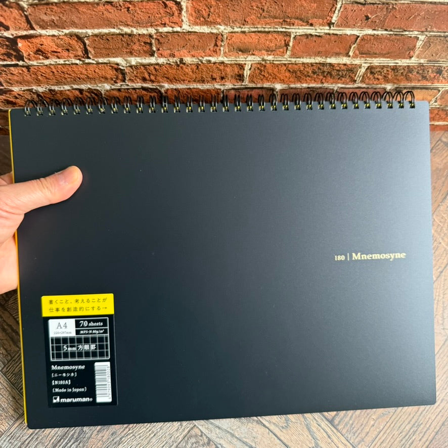 Hand holding the Maruman Mnemosyne A4 landscape notebook to show its size