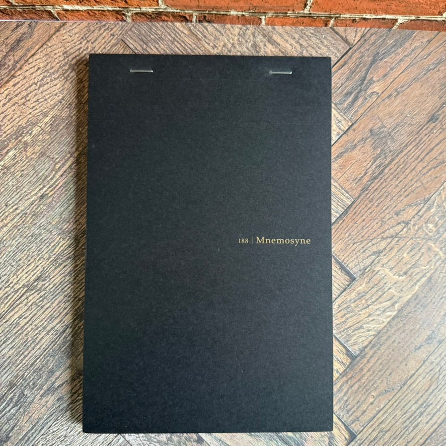 Maruman Mnemosyne 188 A5 notepad with black cover and gold lettering, top-stitched binding
