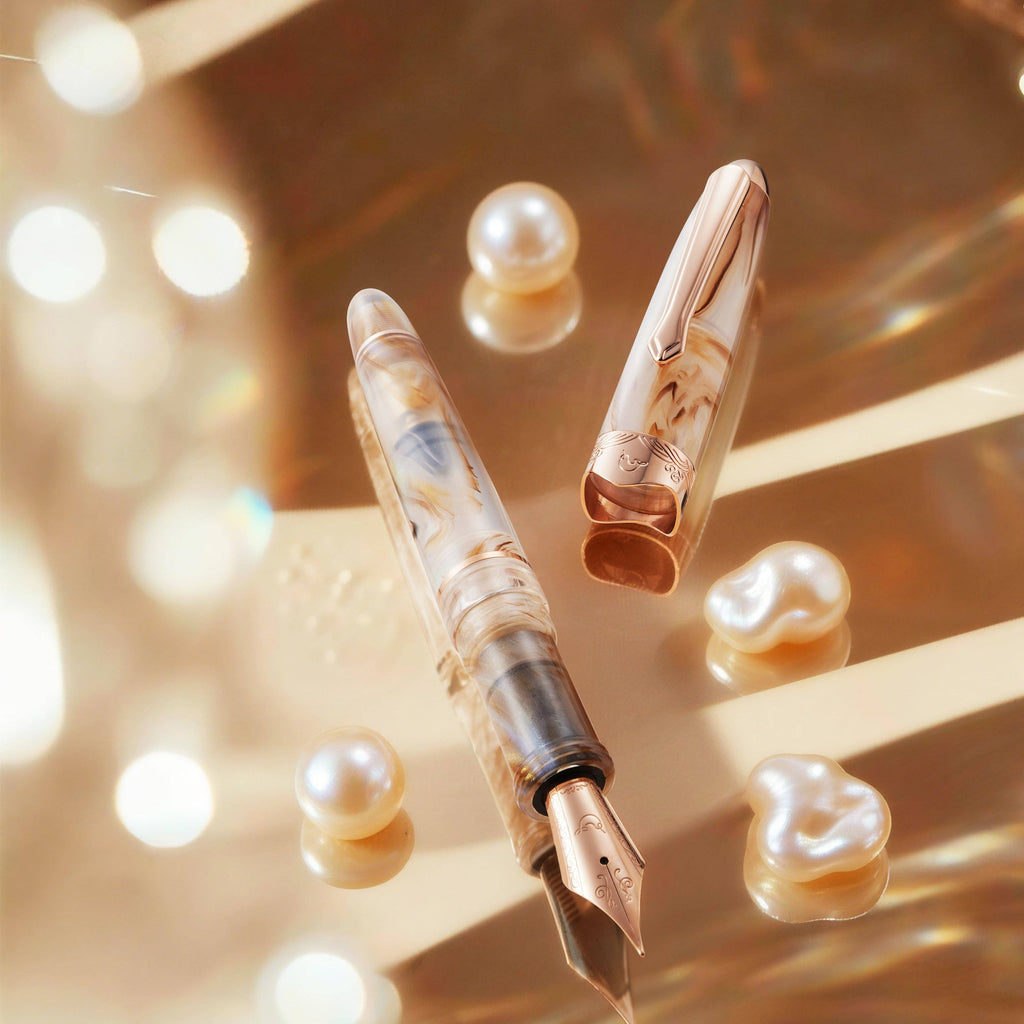 Nahvalur Horizon Pearl pen and cap with rose gold trim among pearls on a golden surface
