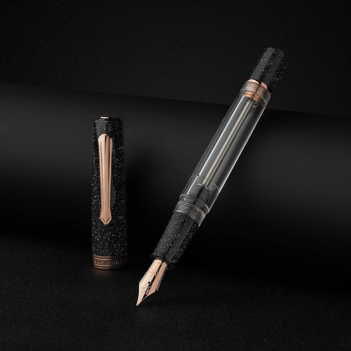 Nahvalur Original Plus Lovina Graphite fountain pen uncapped beside its sparkling black cap on a dark background