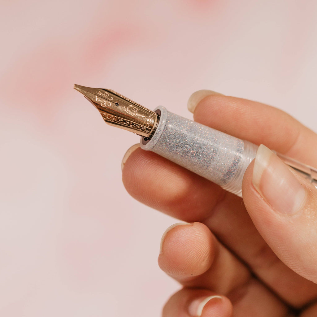 Hand holding the Nahvalur Original Plus by its shimmering grip section, nib facing left
