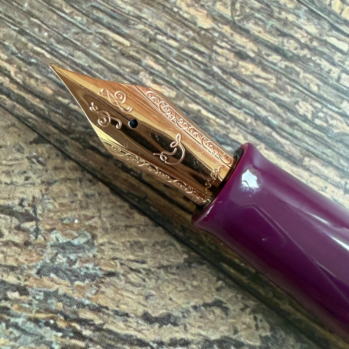 Close-up of the engraved Medium nib and deep violet grip on the Nahvalur Original Violet Ash fountain pen