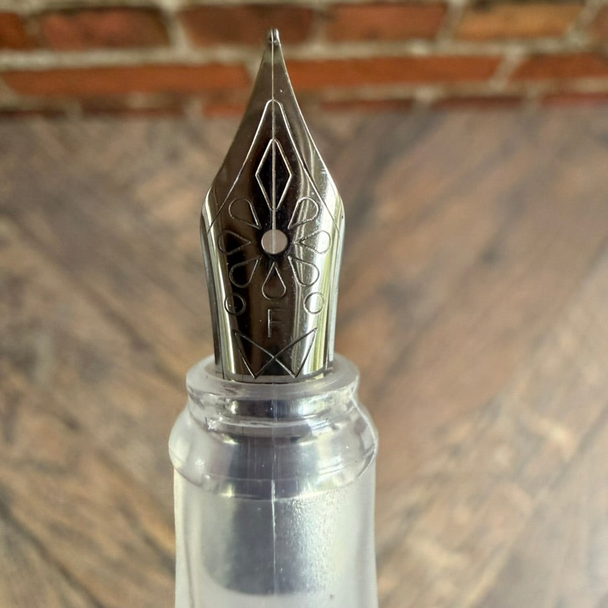 Close-up of the Nahvalur Triad's silver-plated stainless steel nib with floral engraving, marked F for fine