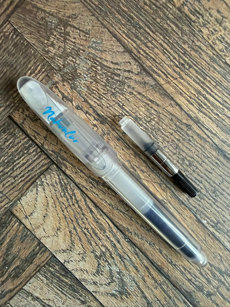 Nahvalur Triad demonstrator fountain pen beside the included ink cartridge