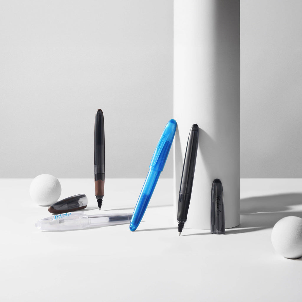 Nahvalur Triad fountain pens in several colors arranged with white props; this listing is the clear demonstrator