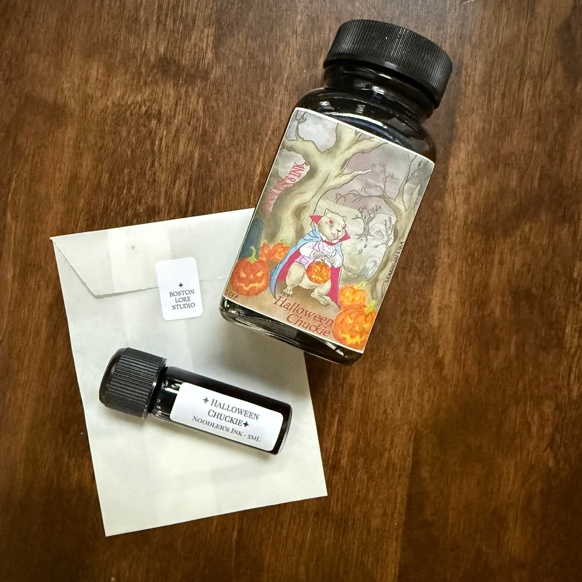 Noodler's Halloween Chuckie original bottle and 5 mL Archive Bottle on a glassine envelope
