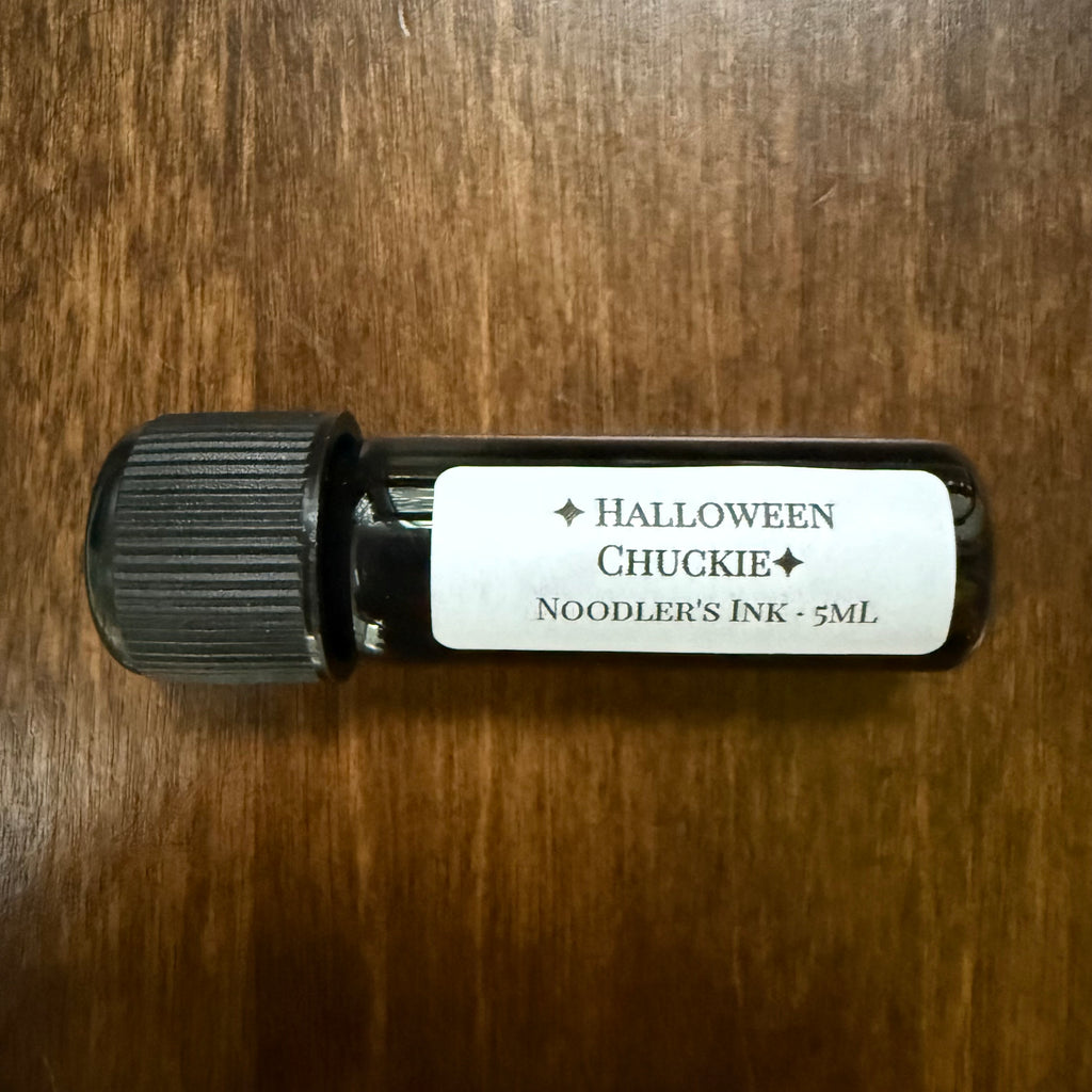 Noodler's Halloween Chuckie 5 mL Archive Bottle lying on its side showing the ink name label