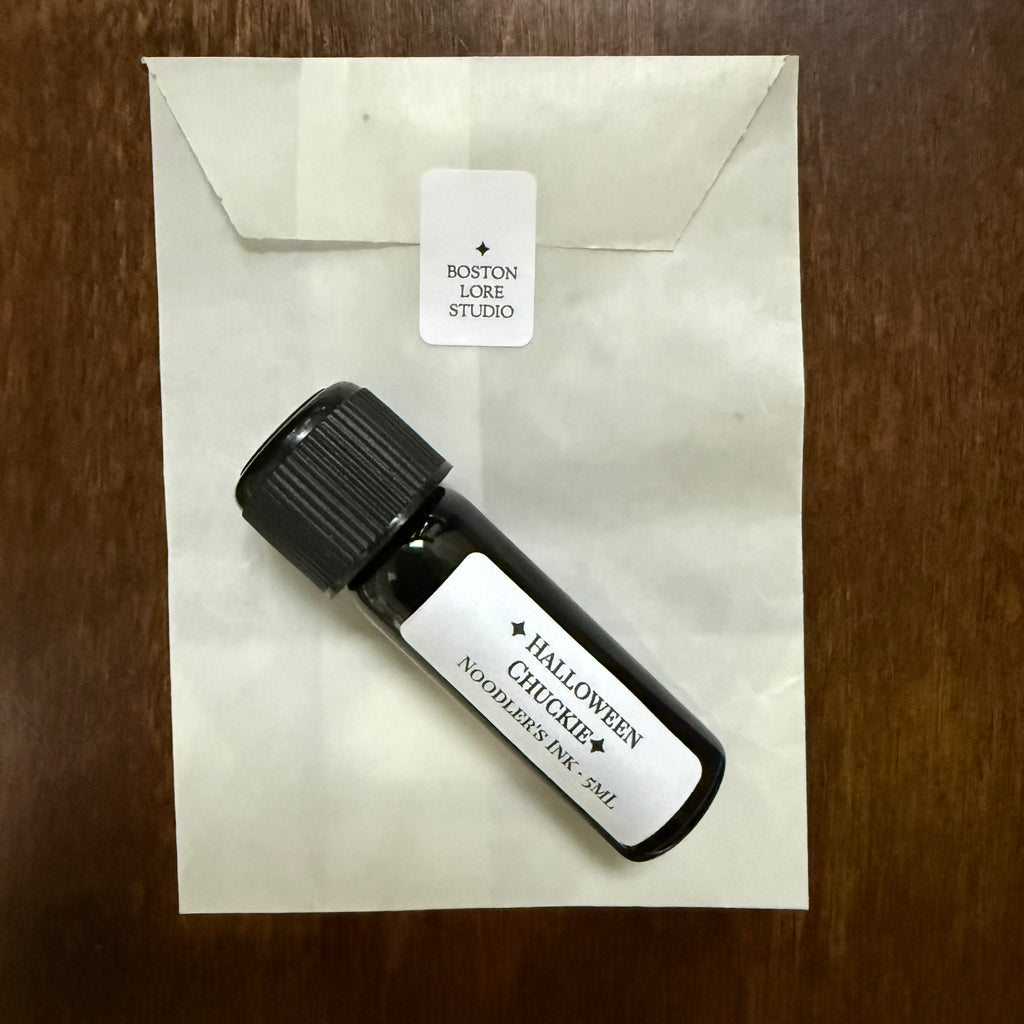 Noodler's Halloween Chuckie 5 mL Archive Bottle resting on its glassine envelope