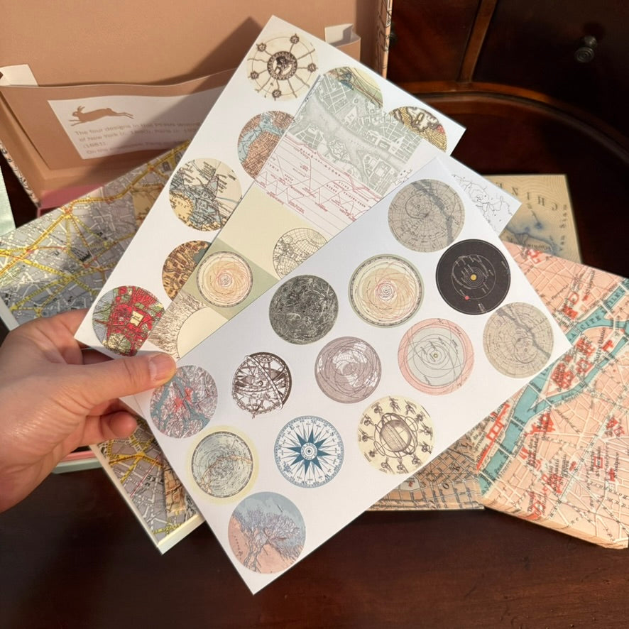 Close view of round vintage map stickers and labels from the PEPIN Maps Letter Writing Set