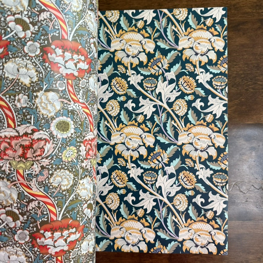 Open PEPIN William Morris paper book showing red, blue, and ochre floral patterns