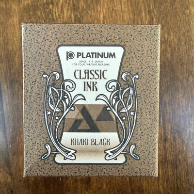 Platinum Classic Khaki Black 60 mL ink box with ornamental black-and-white artwork on brown patterned packaging, photographed on a wooden surface.