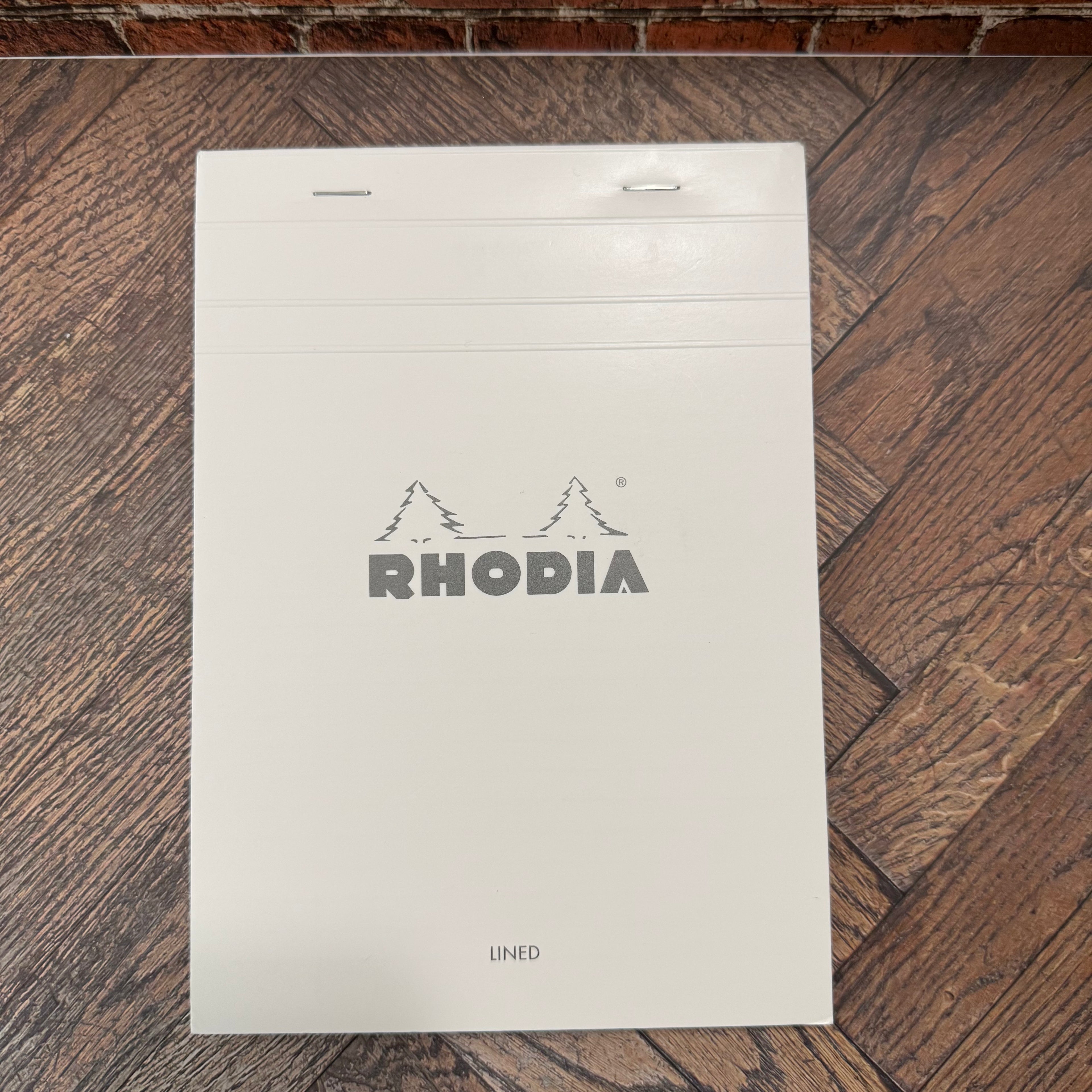 White Rhodia Ice No.16 A5 lined notepad with silver Rhodia logo and top-stapled fold-back cover
